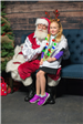 Young Girl Sitting on Santa Claus Lap