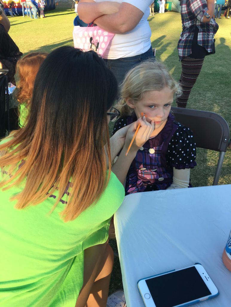 Face Painting Station with child having a pumpkin painted on their face